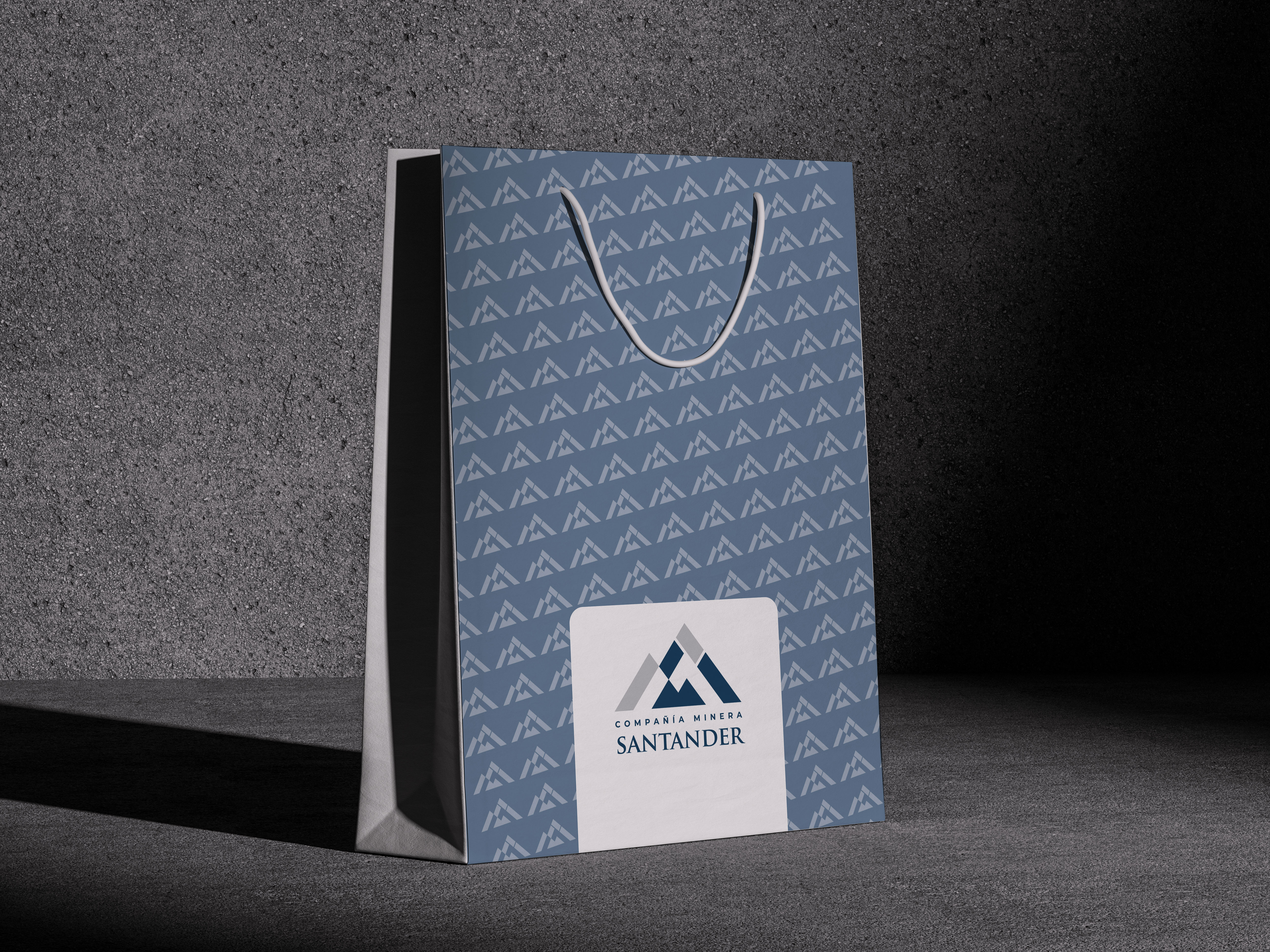 Bolsa corporativa azul con el patrón de montañas y la etiqueta de Compañía Minera Santander
